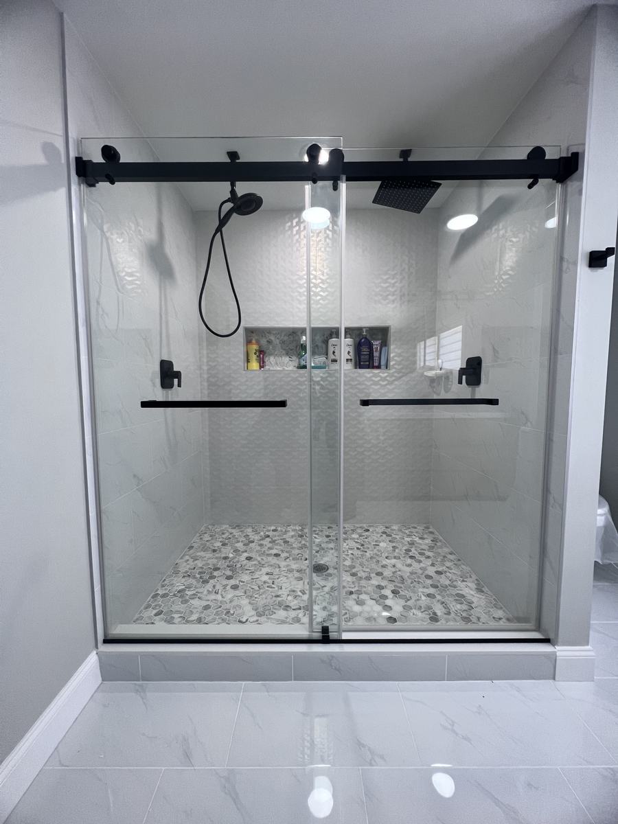 Frameless double sliding shower doors with matte black hardware